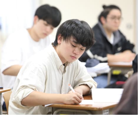 教室で熱心にノートを取る学生たちの様子
