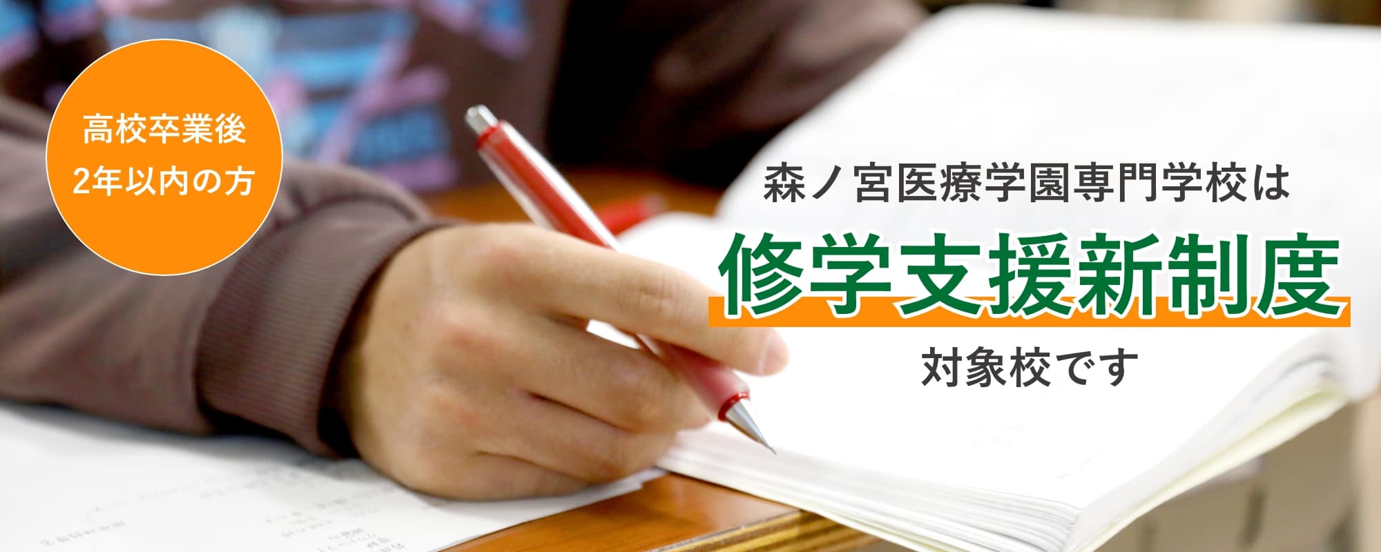 ノートにペンで書き込みをする学生の手元の様子。森ノ宮医療学園専門学校の修学支援新制度対象校であることを伝えるビジュアル
