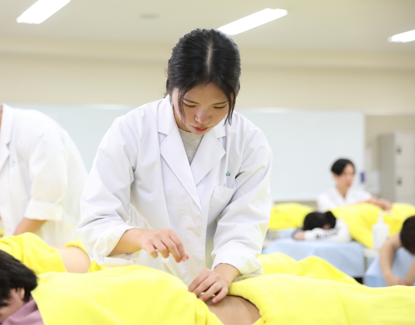 臨床実習で実際に患者に鍼を打つ学生の真剣な様子